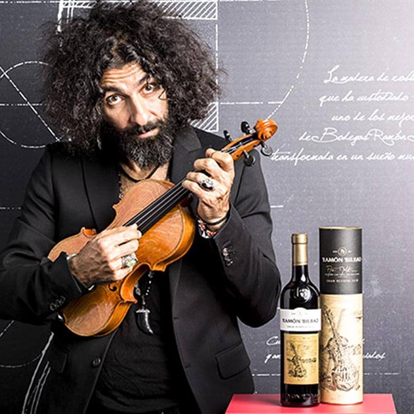Ara Malikian posa con un violín y una botella de vino de Ramón Bilbao