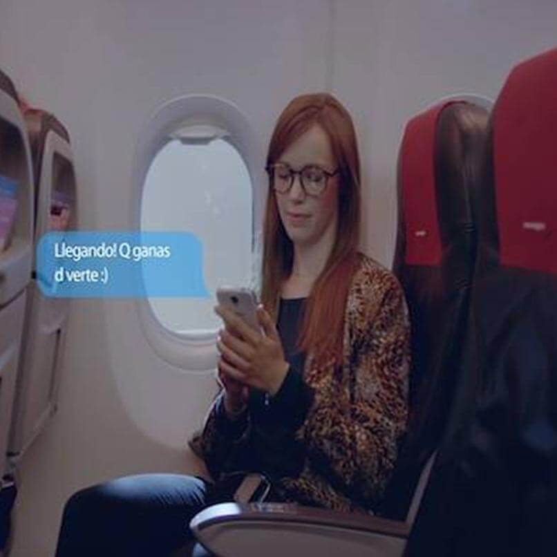 Una chica envía un mensaje desde su asiento en un avión de Norwegian.