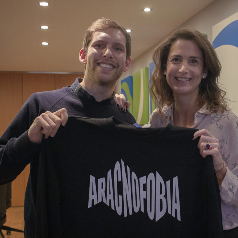 Emma Ruíz de Azcárate de Pelayo, y Javier de la Rocha de Aracnofobia sujetan una camiseta con el logo de la agencia de publicidad