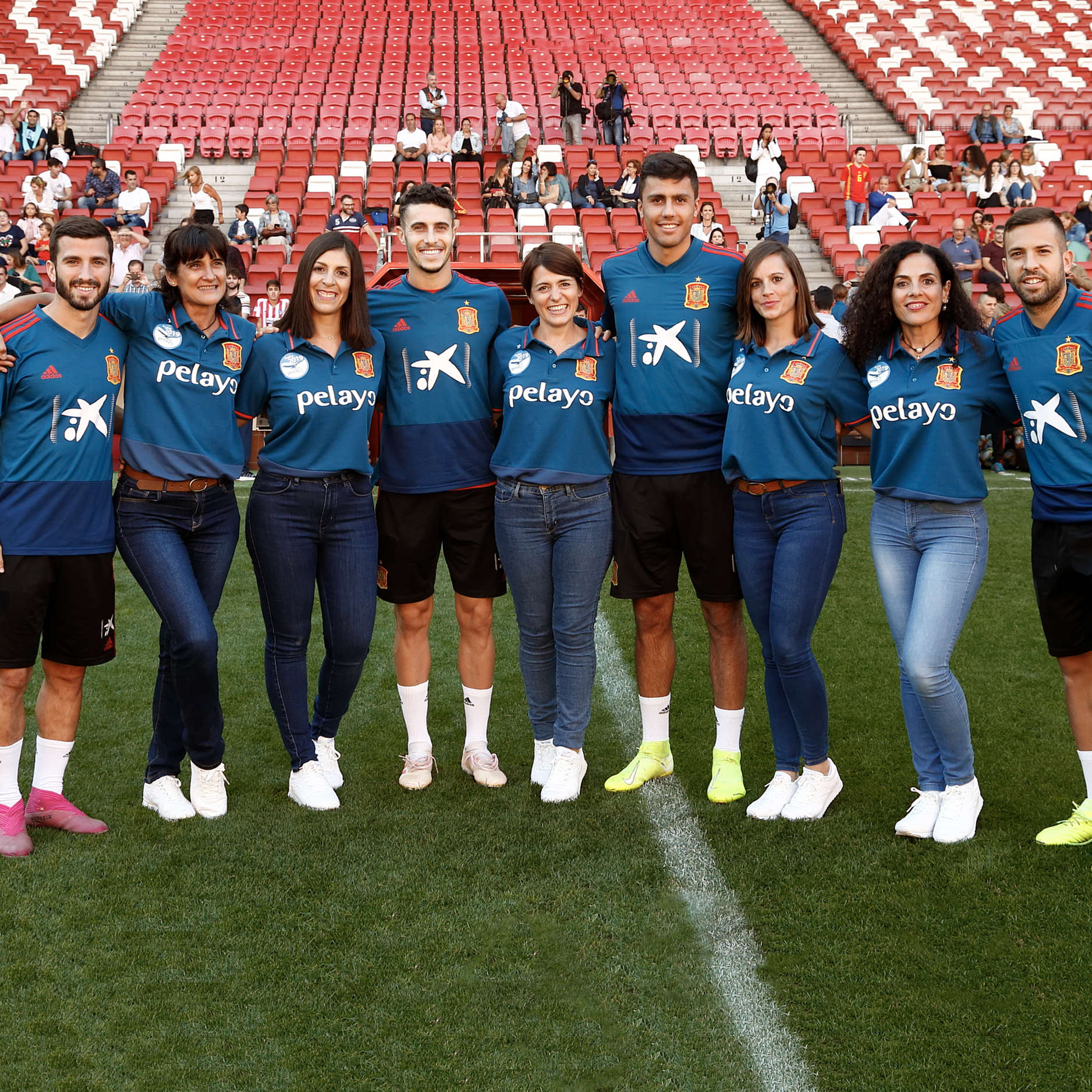 Jugadores de la Selección Española de Fútbol posan a pie de campo con las integrantes del reto Pelayo Vida Andes 2019