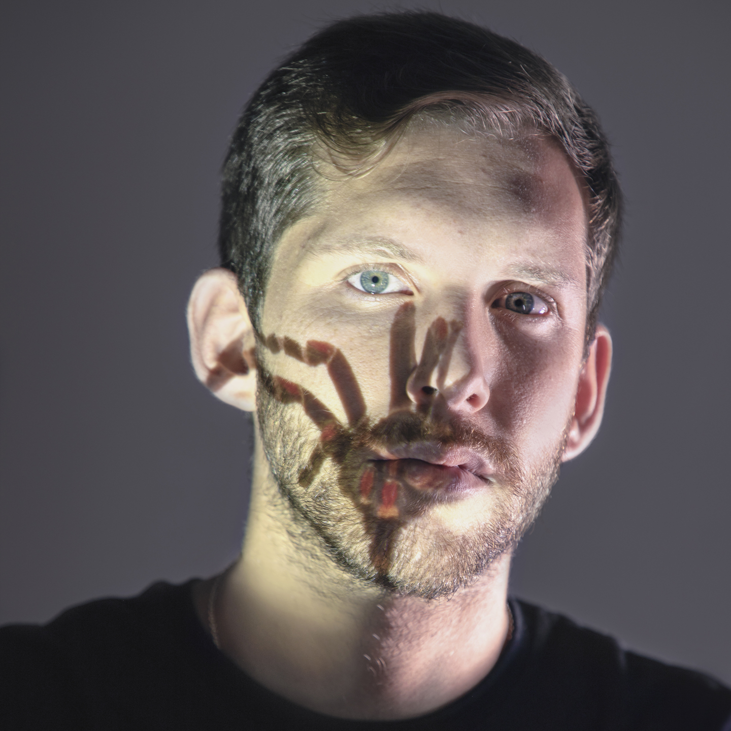 Foto corporativa de Javier con una araña proyectada sobre su cara.